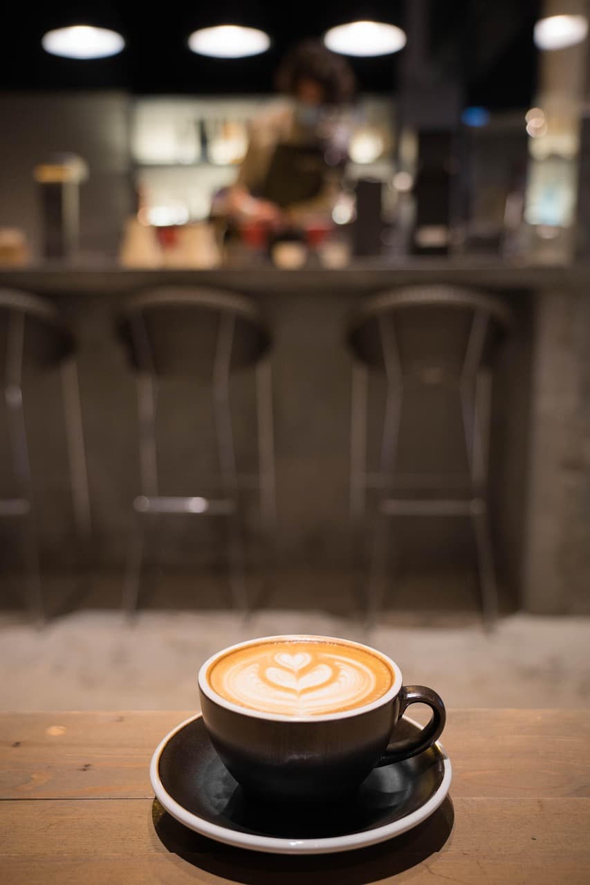 Frisch gebrühter Cappuccino mit Latte-Art auf einem Tisch im Café Zuckersüss